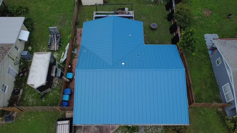 Aerial view of a new blue metal roof on a home