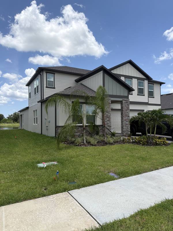 Two-story home exterior with a gabled roofline under a blue sky