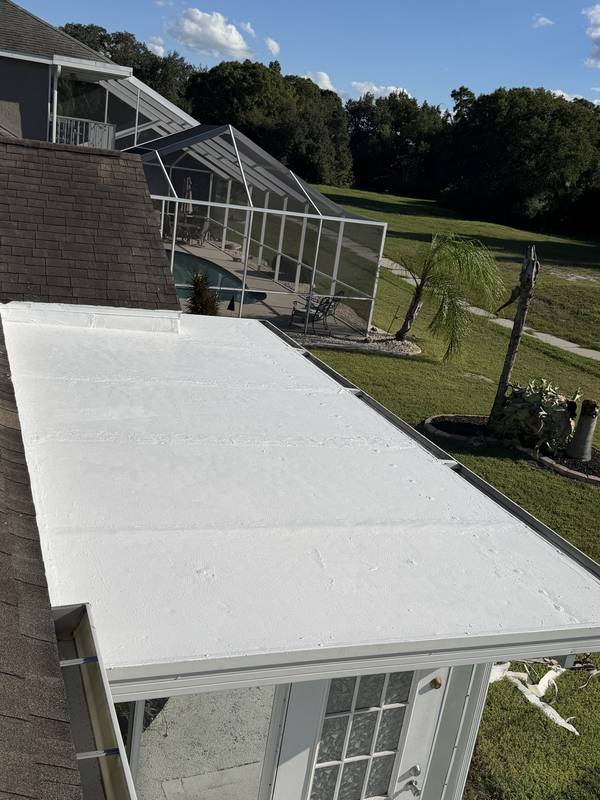 White low-slope roof section beside a screened pool enclosure